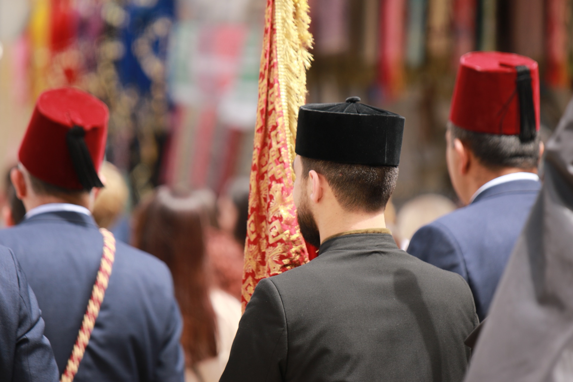 أعضاء موكب أرمني بطرابيش حمر يتبعون رايةً مطرزة عبر القدس