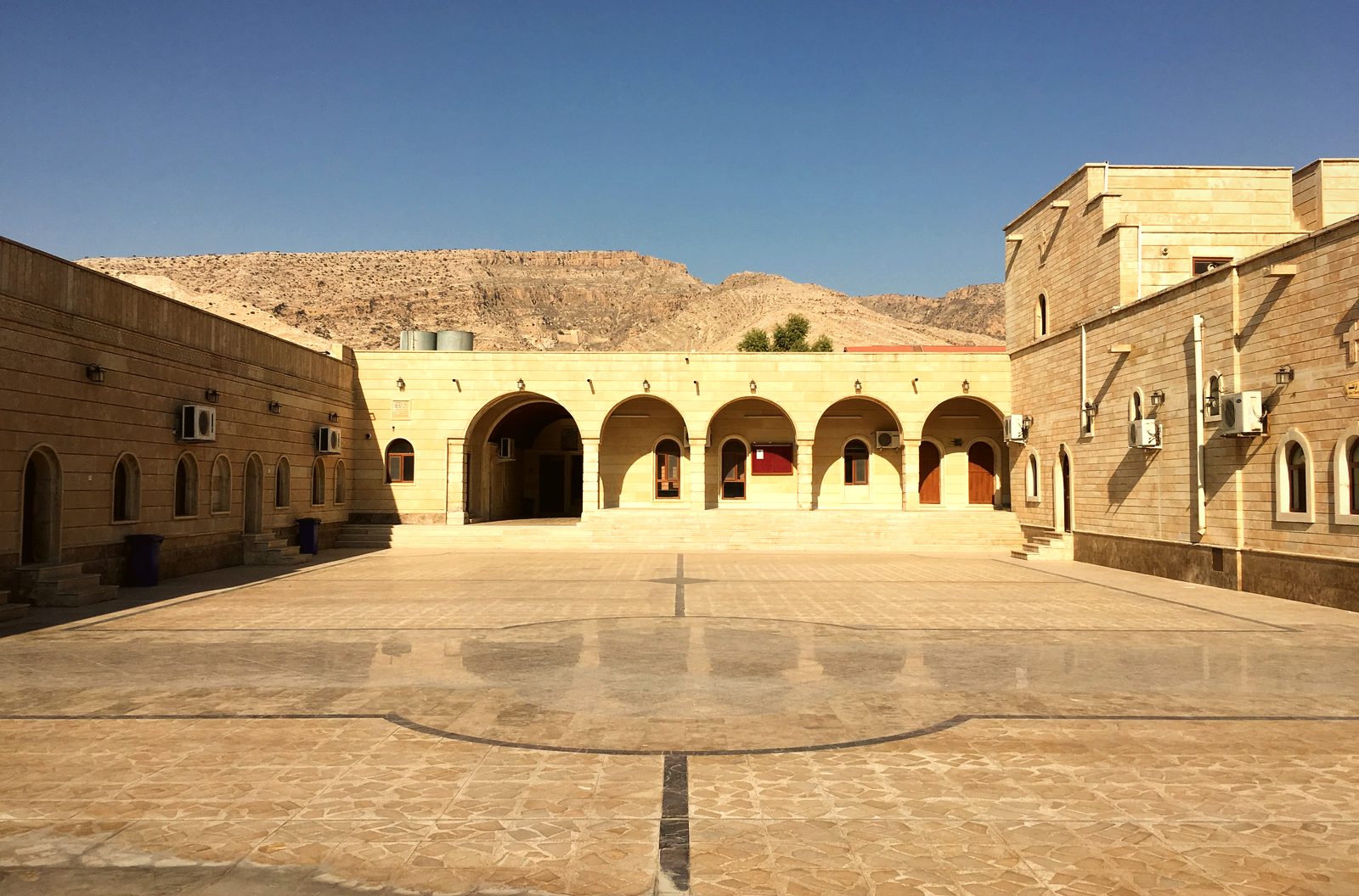 The broad stone courtyard and arched gallery of the monastery of Our Lady of the Seeds in Alqosh