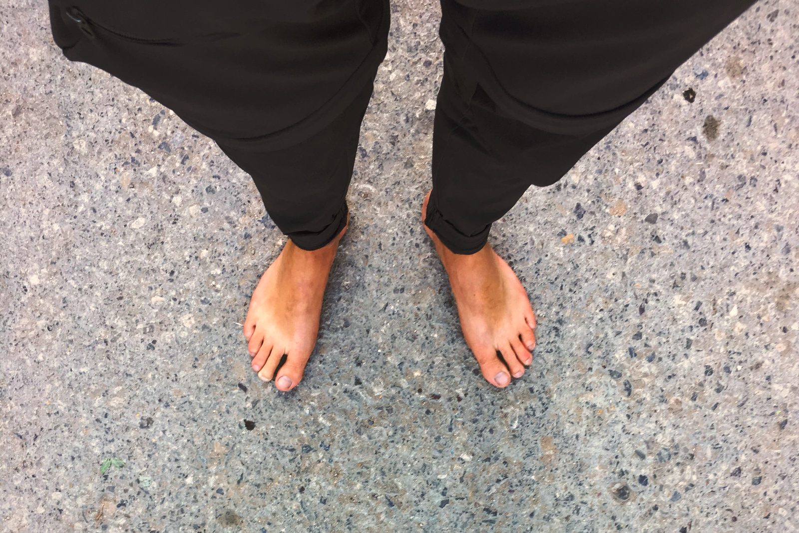 A pair of bare feet on the speckled stone paving of the Lalish sanctuary